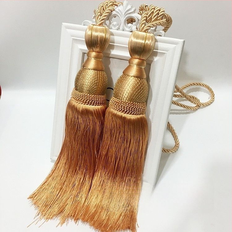 Aizkaru aukli - zelta stieples bumbiņa ar pušķi (audums)