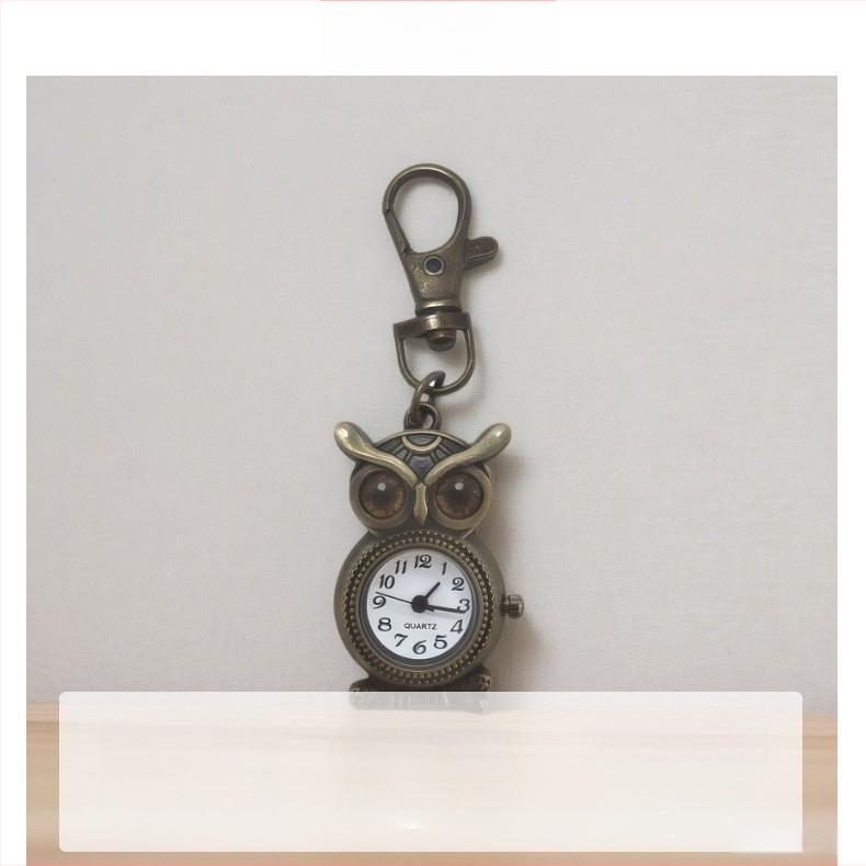 Pelėdos motyvo kišeninis laikrodis, retro stiliaus, dekoratyvus, kvarcinis mechanizmas Z618, apvalus dial diametrą 15 mm, storis 8 mm, korpusas iš cinko lydinio, raktų pakabuko sagtis, logotipas gali būti spausdinamas