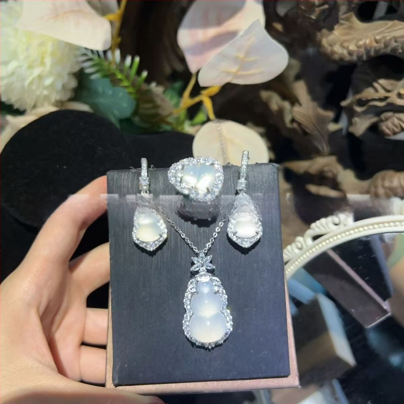 Sudraba pārklājuma chalcedona rotaslietu komplekts: dabīgais chalcedons kulons, auskari un rokassprādze; materiāls: chalcedons, apdare: pulēšana, avots: dabisks, stils: moderns minimālais