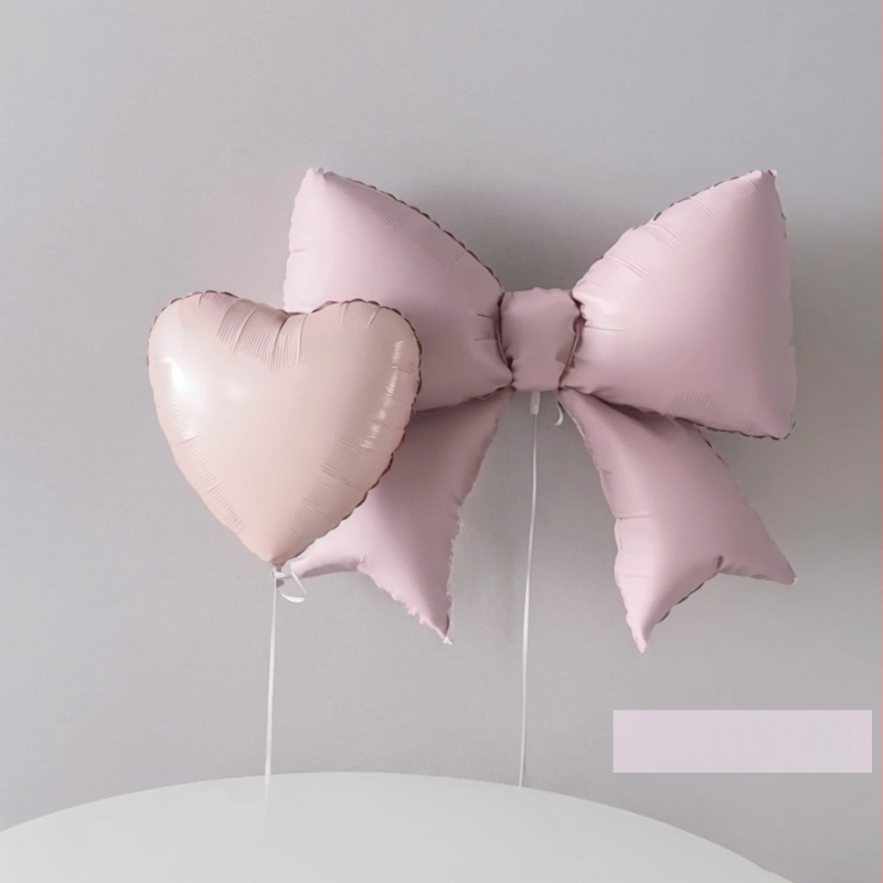 Mat ružičasti balon u obliku mašne i srca od aluminijske folije – dekoracija za fotografiranje na dječjem rođendanu