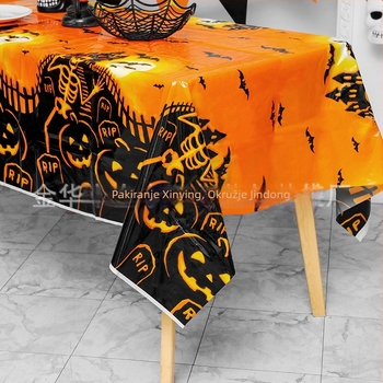 Jednokratni plastični stolnjak za Halloween party dekoraciju, s motivima bundeve, lubanje i šišmiša, u karikaturalnom horor stilu.