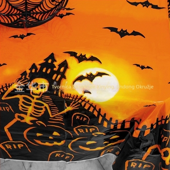 Jednokratni plastični stolnjak za Halloween party dekoraciju, s motivima bundeve, lubanje i šišmiša, u karikaturalnom horor stilu.