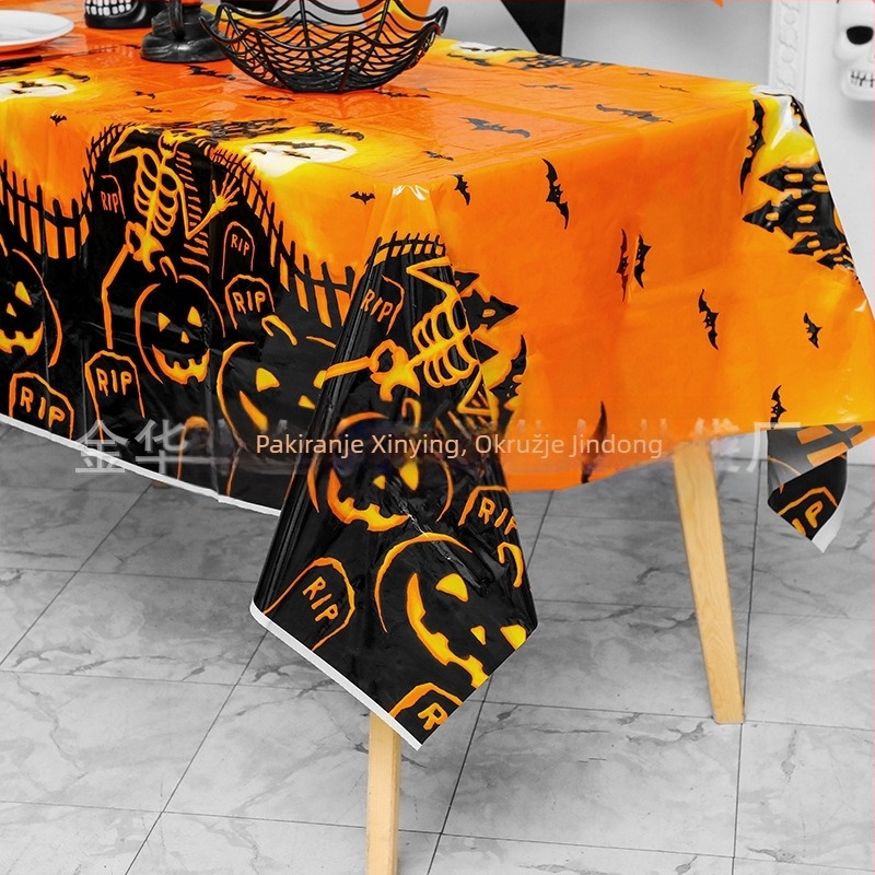 Jednokratni plastični stolnjak za Halloween party dekoraciju, s motivima bundeve, lubanje i šišmiša, u karikaturalnom horor stilu.