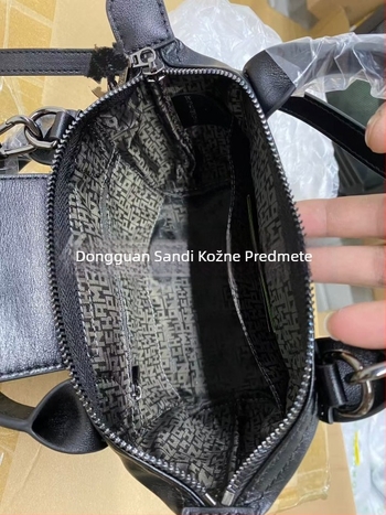 Torba od prave kože u obliku dumplinga s poklopcem, platnena podstava, unutarnji džepovi sa zipom, džep za telefon i osobnu iskaznicu, jedna naramenica