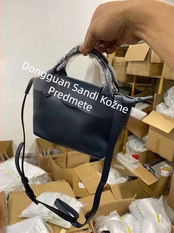 Torba od prave kože u obliku dumplinga s poklopcem, platnena podstava, unutarnji džepovi sa zipom, džep za telefon i osobnu iskaznicu, jedna naramenica