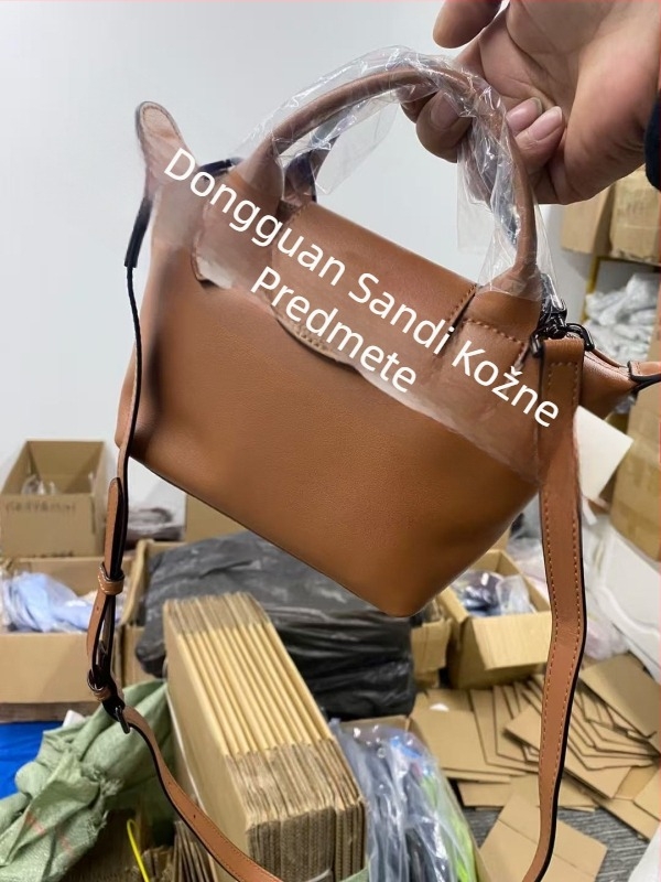 Torba od prave kože u obliku dumplinga s poklopcem, platnena podstava, unutarnji džepovi sa zipom, džep za telefon i osobnu iskaznicu, jedna naramenica