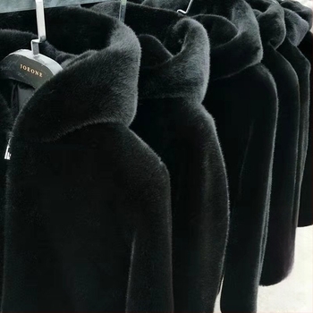 Muški kaput od prave krznene kože (ovčja koža), srednje duljine, opuštenog kroja, kapuljača i zatvarač.