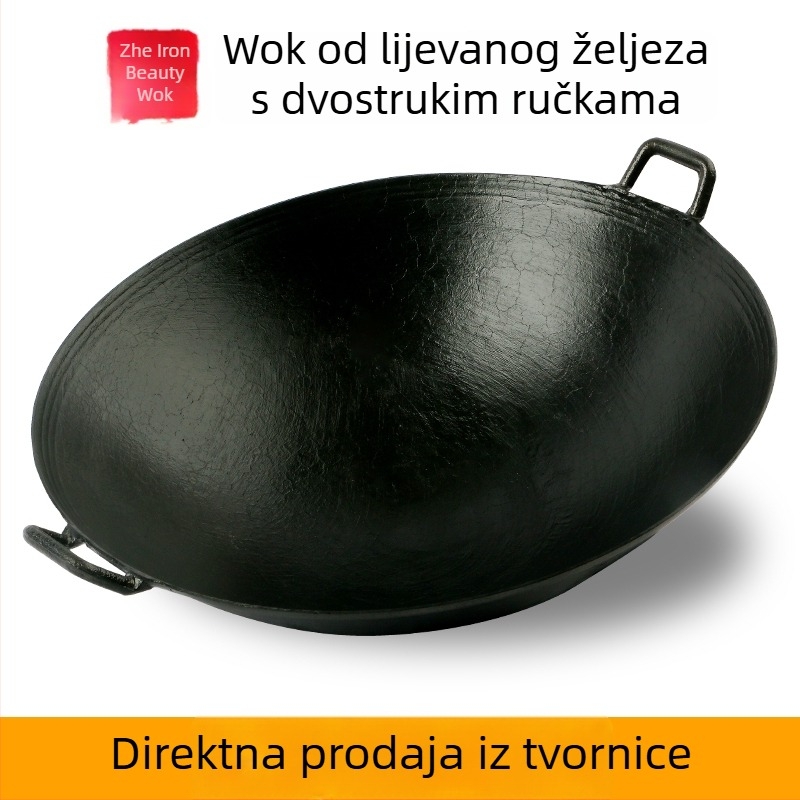 Dvoručna posuda od lijevanog željeza za kućnu upotrebu, tradicionalno seosko drveno ognjište.