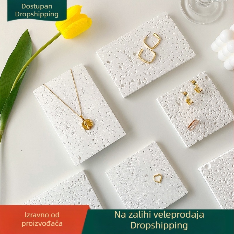 Kamen s rupama, rekvizit za fotografiju nakita – naušnice i ogrlica, dekorativni predmet i pozadina fotografiranja