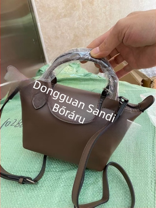Valódi bőrből készült dumpling alakú táska fedéllel, vászon belső bélés, belső cipzáras zseb, telefontartó és személyi igazolvány zseb, egy vállpánt