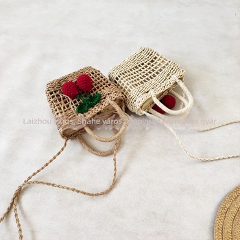 Női keresztpántos szalmából készült táska, függőleges négyszögletes forma, kis négyzet mintázat, szalagos zárás