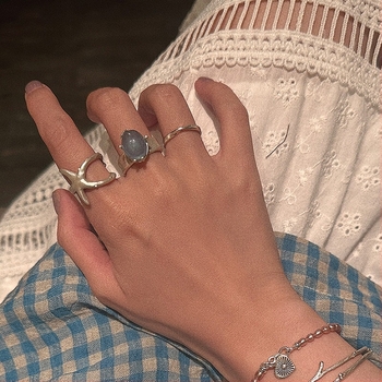 Nyitott geometriájú gyűrű matt felületű ötvözetből, tengeri csillag és macskaszem díszítéssel, elektroplatírozott