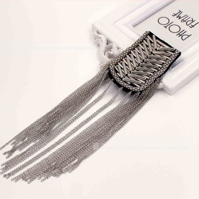 Színpadi ruházat-kiegészítő: bojtos váll-epolett fémes díszítéssel, koreai stílusú, uniszex (Anyag: Keverék; Stílus: Koreai, Uniszex; Díszítés: Bojt; Kezelés: Elektrolitikus platinázás; Kristály: Fehér kristály)