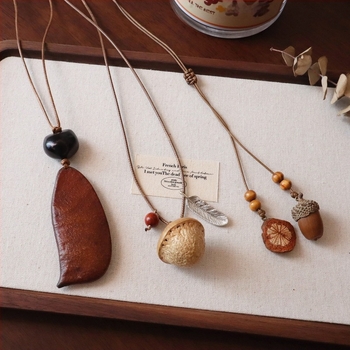 Hosszú pulóverlánc Mori stílusban, virág alakú medállal, anyag: dióhéj, nőies etnikus dizájn, őszi 2025 megjelenés