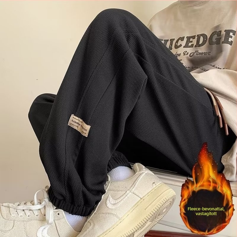 Kényelmes, laza szabású sportnadrág, középmagas derekú, zsinóros zárás, poliészter-keverék anyag és elasztikus.