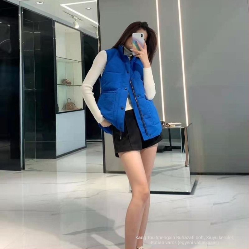 Mellény tollal töltött, álló gallérral, cipzárral; töltet: lúd toll; tartalom: 81–85%; fő anyag: poliészter; hossz: 50–65 cm