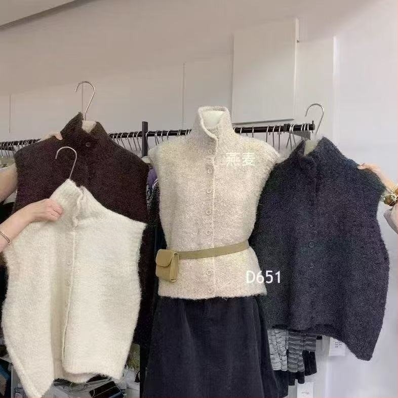 Kötött ujjatlan mellény álló gallérral, elöl egysoros gombolás, poliészter- akril keverék 30–50% mindkettő, hossz 50–65 cm, téli 2025, elegáns ingázó stílus