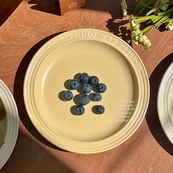 Kerámiából készült lapos tányér gravírozott felülettel és domborított betűkkel, kerek forma, modern egyszerű stílus