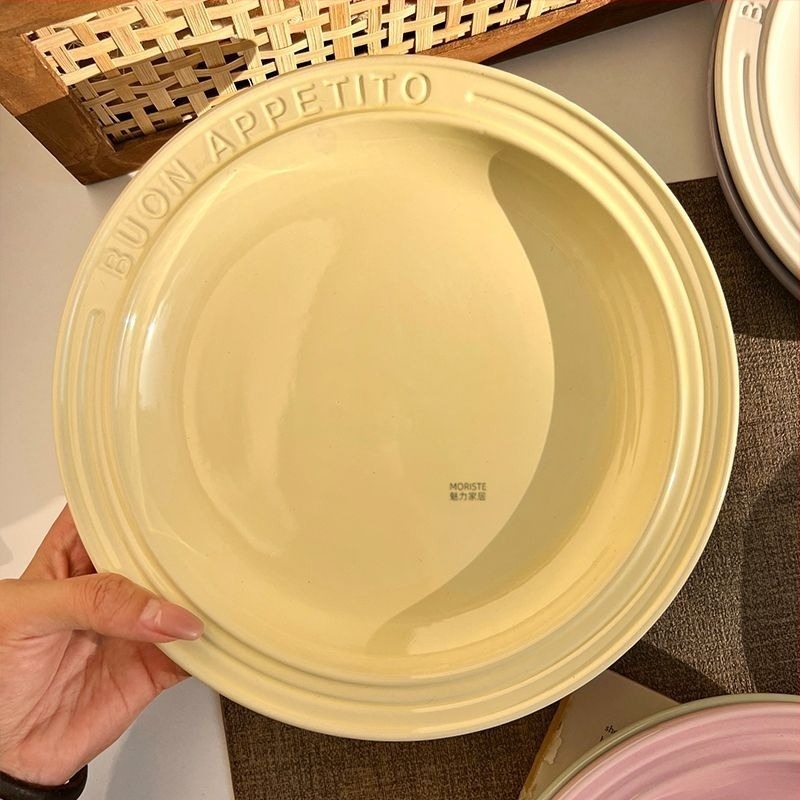 Kerámiából készült lapos tányér gravírozott felülettel és domborított betűkkel, kerek forma, modern egyszerű stílus