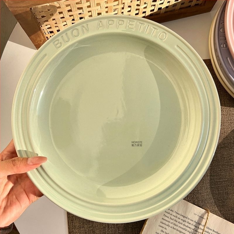 Kerámiából készült lapos tányér gravírozott felülettel és domborított betűkkel, kerek forma, modern egyszerű stílus