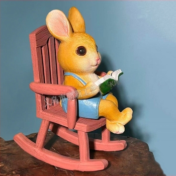 Olvasó nyúl hintázó székkel – kültéri dekoráció kertbe és erkélyre, cartoon stílusú, szintetikus gyantából készült