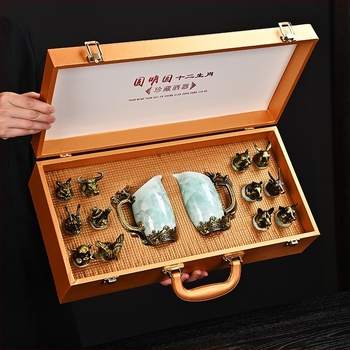 Porcelánból készült, kristályos mázzal bevont tizenkét zodiákus motívumos boros készlet, dupla adagolóval, tizenkét pohárral, fémbázissal és bőr ajándékdobozzal