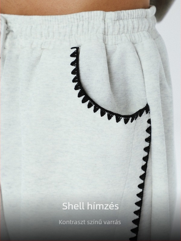 Őszi 2025-ös kiadás: bontott szabású pamut tréningnadrág, shell hímzés, color-blocking, egyenes szabás.