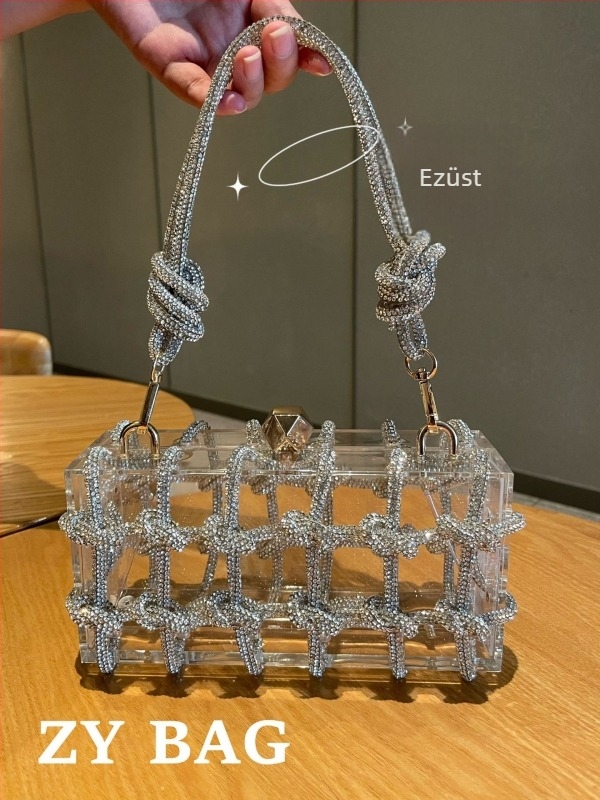 Akryl doboz formájú esté táska kristályokkal, átlátszó, zárható, belső zsebek a telefon számára és azonosító kártya, bélés nélkül, egy vállpánttal (Anyaga: akril; Forma: doboz; Zár: zár; Belső zsebek: telefon, azonosító kártya; Belső anyag: bélés hiányzik)