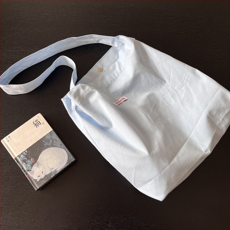 Vászonból készült oldaltáska városi egyszerűség stílusban, mindennapi használatra, 2023 nyár.