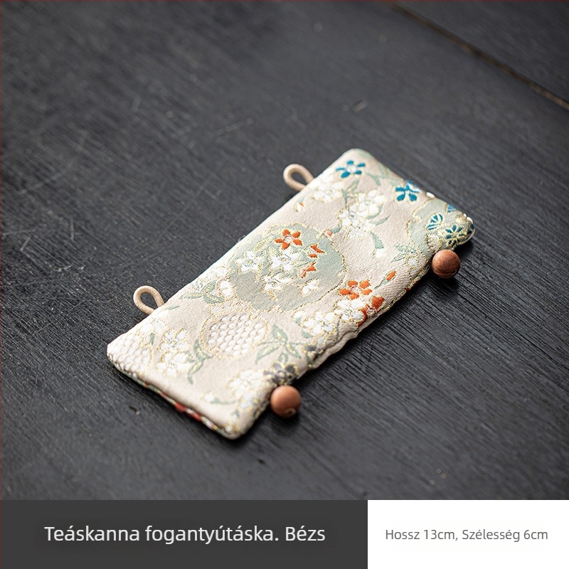 Ezüst színű vas teáskanna fogantyújának hőszigetelő párnája brokát anyagú borítással, japán stílusban