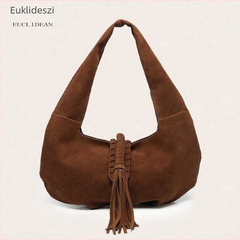 Női válltáska meleg barna árnyalatban, bojtokkal és félhold alakú formával, velúrhatású felülettel, retro stílusban mindennapi használatra