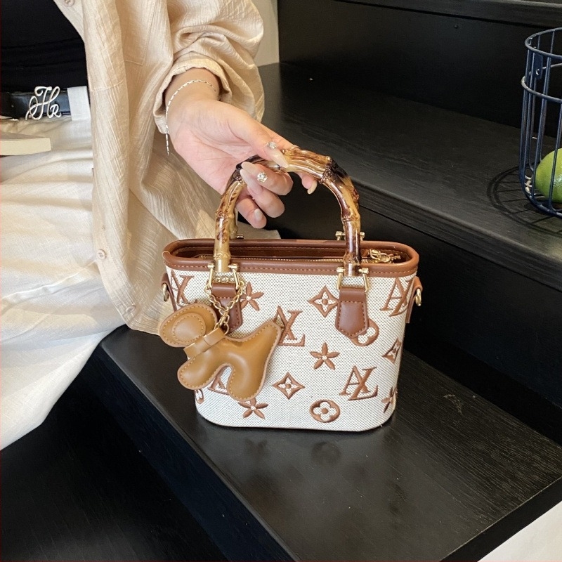 Vödrös táska betűkkel nyomtatva, fa fogantyúval, vállon vagy crossbody viselésre.