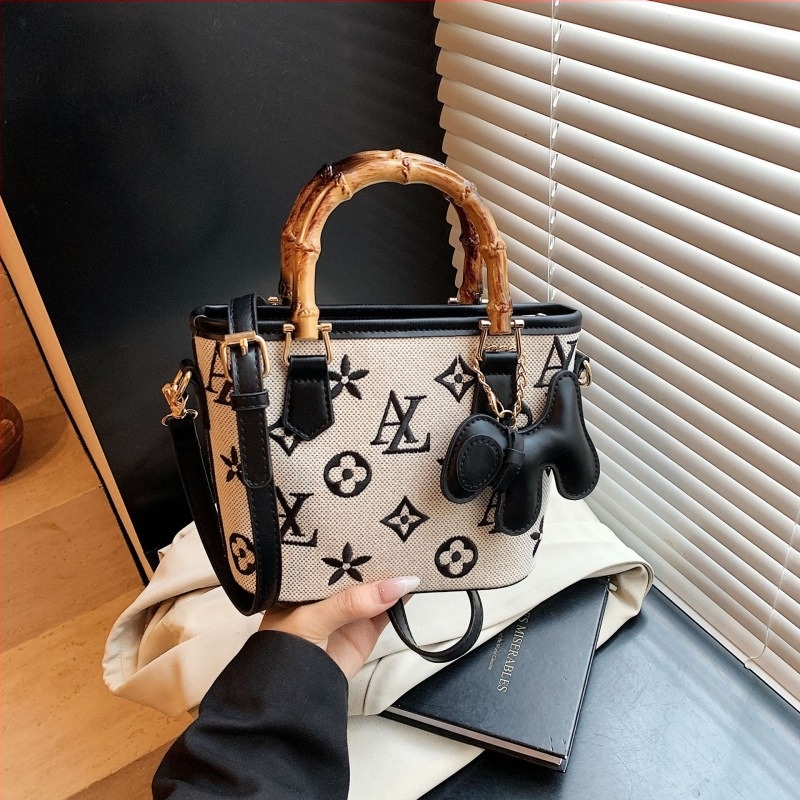 Vödrös táska betűkkel nyomtatva, fa fogantyúval, vállon vagy crossbody viselésre.