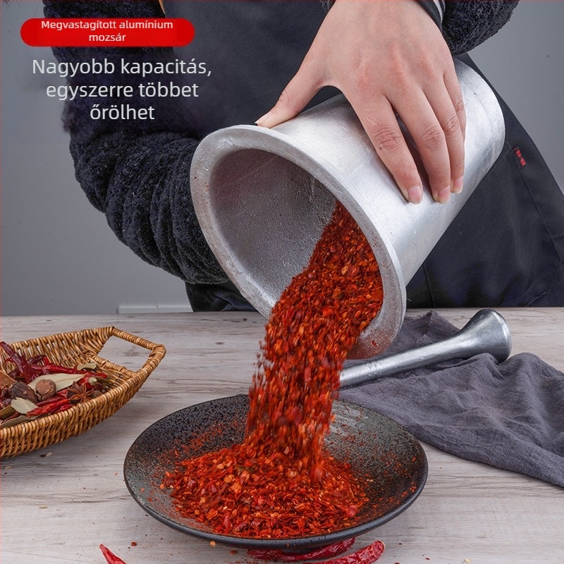 Antik alumínium mozsár és törőpálca a fokhagyma és a csípős paprika őrléséhez