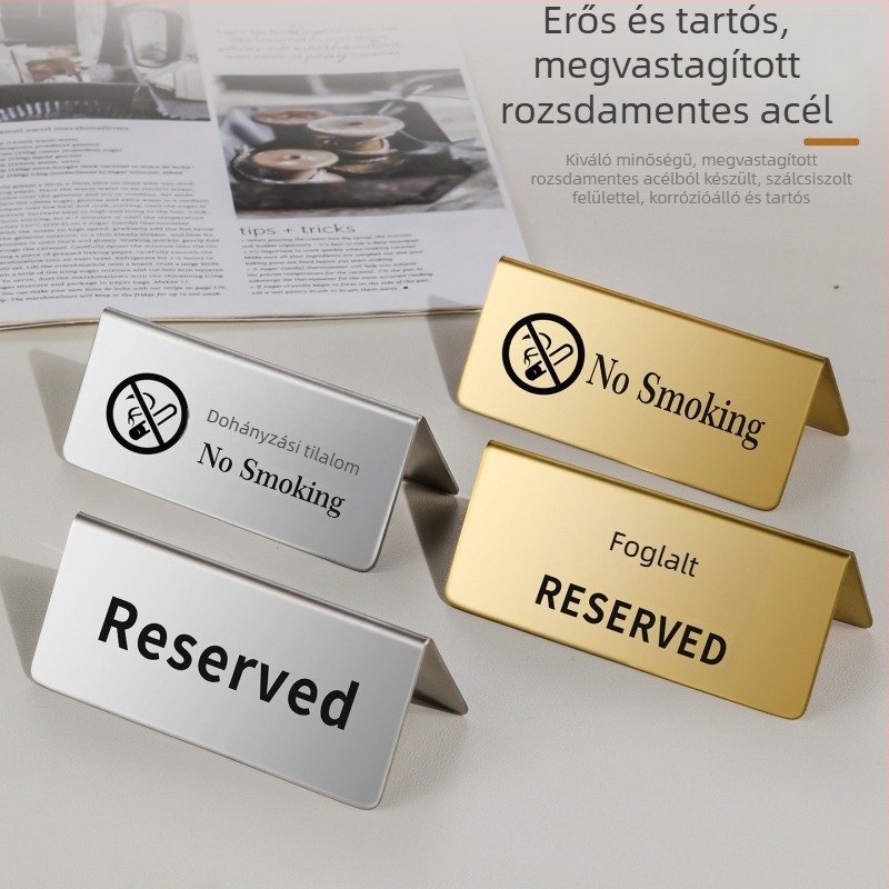 Rozsdamentes acélból készült foglalt hely jelző arany befejezéssel, asztalszám plakett és kétnyelvű No Smoking jelzés.