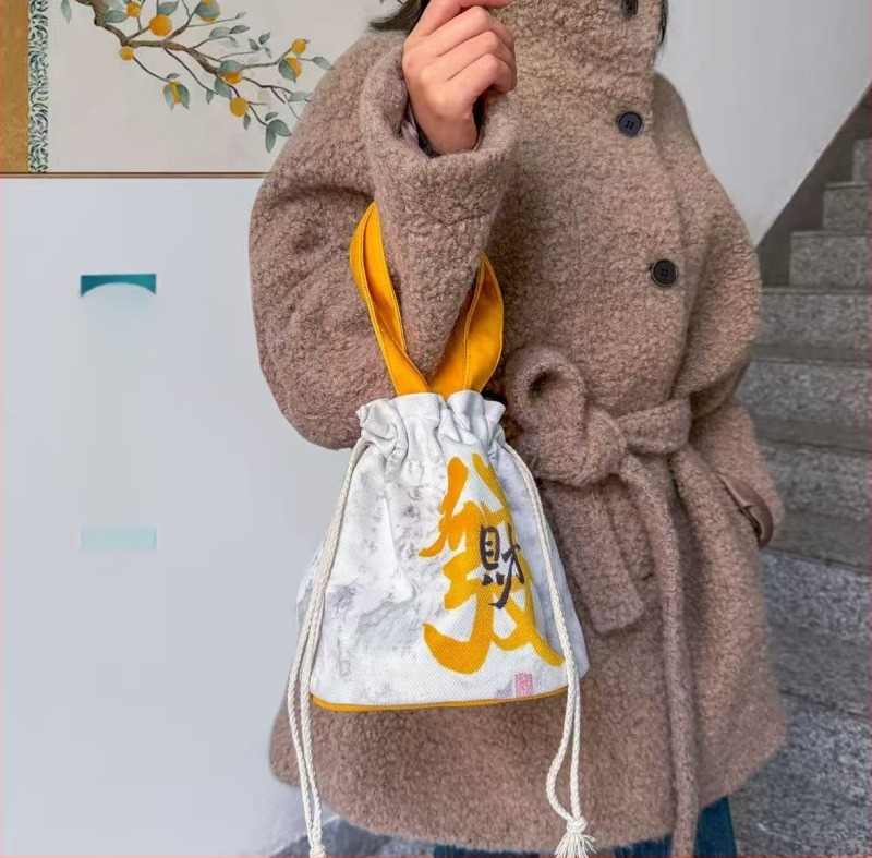 Geantă bucket din canvas, unisex, închidere cu șnur, interior cu buzunare multiple (telefon, documente, laptop, cameră) – toamnă 2025