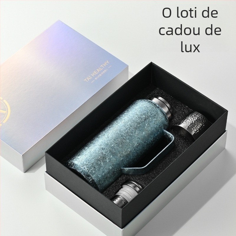 Termos din titan pur, izolație în vid, termometru mecanic, compartiment pentru ceai și capac cu deschidere basculantă.