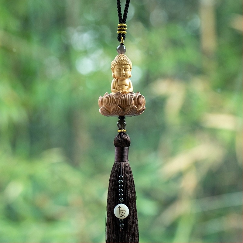 Pandantiv auto din lemn cu Buddha mic, bază de lotus și ciucuri lungi; decor interior modern.