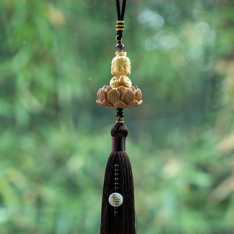Pandantiv auto din lemn cu Buddha mic, bază de lotus și ciucuri lungi; decor interior modern.