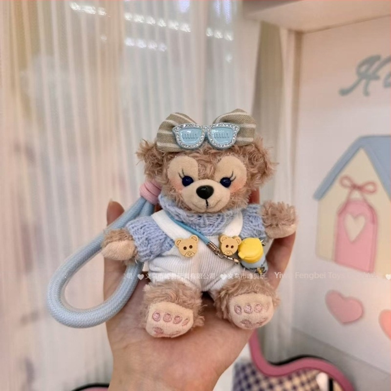 Păpușă ursuleț de pluș cu pandantiv, salopetă cu bretele și accesorii pentru îmbrăcare
