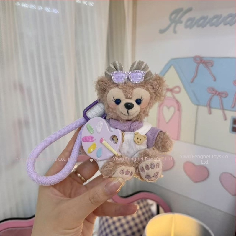 Păpușă ursuleț de pluș cu pandantiv, salopetă cu bretele și accesorii pentru îmbrăcare