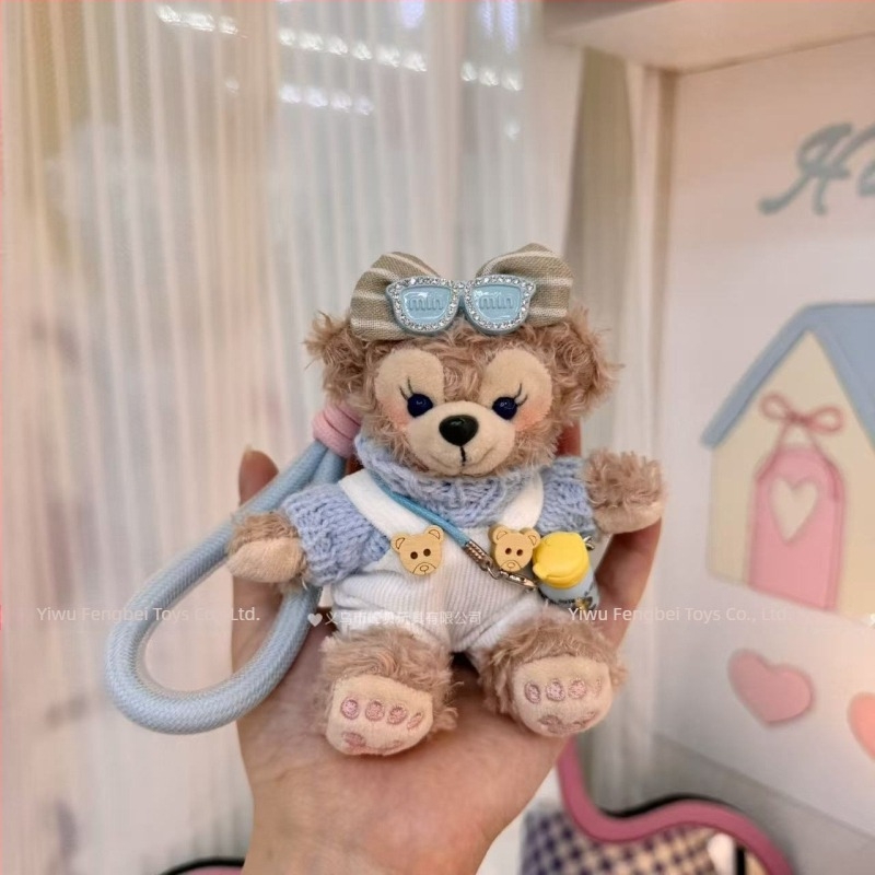 Păpușă ursuleț de pluș cu pandantiv, salopetă cu bretele și accesorii pentru îmbrăcare