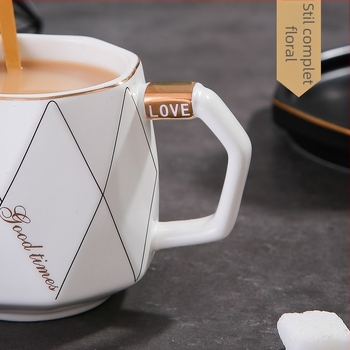 Set ceramic creativ pentru cafea: ceașcă, farfurioară, tavă cu margine aurie și lingură.
