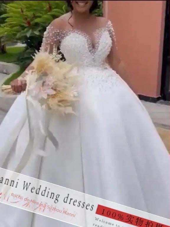 Rochie de mireasă din dantelă cu mâneci lungi, decolteu adânc în V și fustă pufoasă pentru mirese africane